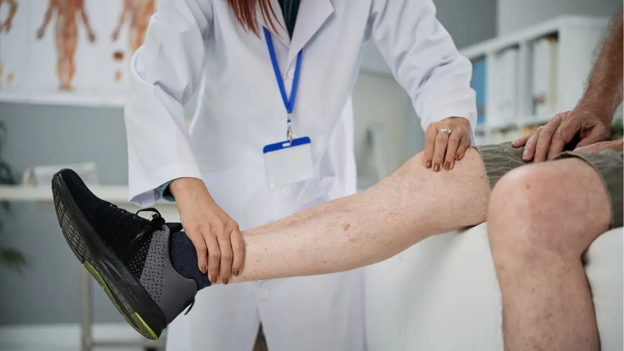 Un médico explora a un paciente para detectar si padece lesiones en el menisco
