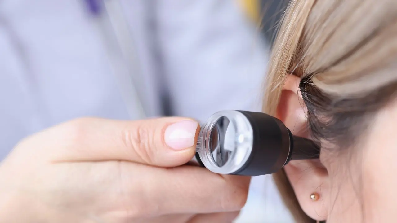 Una otorrino revisa el oído de una paciente que padece de otitis recurrente en adultos