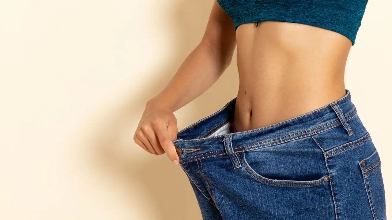 Vista de una mujer al que el pantalón le queda grande a causa de una pérdida de peso involuntaria